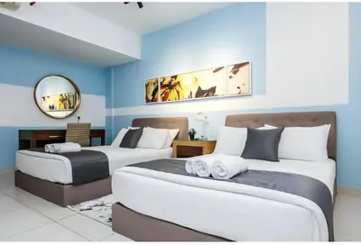 two beds in a room with blue walls at Bmc Homez Suite 3towers in Kuala Lumpur