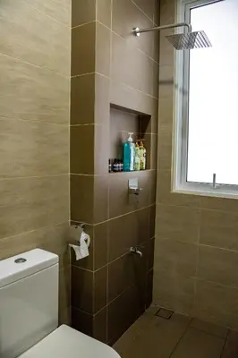 a bathroom with a shower with a toilet and a window at Entire Apartment in Kuala Lumpur, Infinity Pool!! in Kuala Lumpur