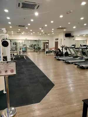 a gym with rows of treadmills and elliptical machines at Global suites at time square KL in Kuala Lumpur
