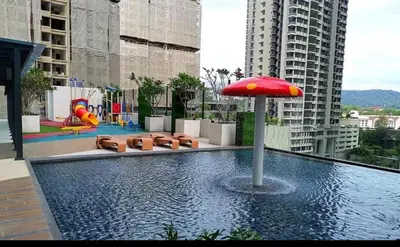 a pool with a red umbrella and a playground at 10 Pax stay in Kl Area in Kuala Lumpur