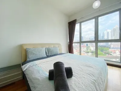 a bedroom with a bed with a large window at Regalia Residences And Suites By The Relaxstay in Kuala Lumpur