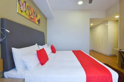 a bedroom with a large bed with red pillows at Palette Bukit Bintang Formerly Suasana Suites in Kuala Lumpur