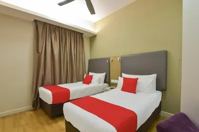 two beds in a hotel room with red pillows at Palette Bukit Bintang Formerly Suasana Suites in Kuala Lumpur