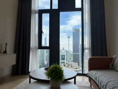 a living room with a large window with a view of a city at Star Residences One in Kuala Lumpur