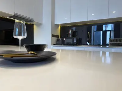 a white kitchen with a plate and a wine glass at Star Residences One in Kuala Lumpur