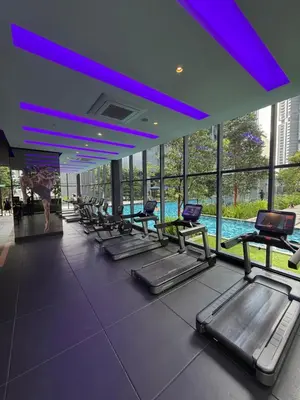 a row of treadmills in a gym with a pool at Star Residences One in Kuala Lumpur