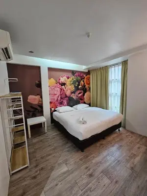 a bedroom with a large bed with a flower mural at V Garden Hotel by Minsu in Kuala Lumpur