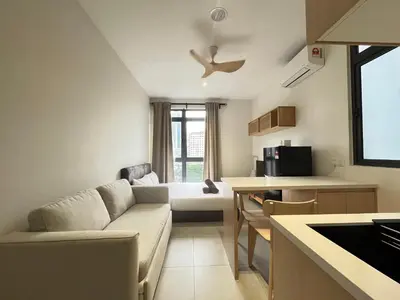 a living room with a couch and a kitchen at Neu Suites By The Relaxstay in Kuala Lumpur