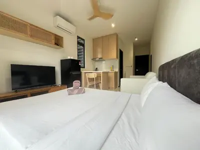 a bedroom with a large white bed with a flat screen tv at Neu Suites By The Relaxstay in Kuala Lumpur