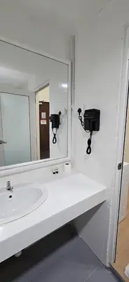 a white bathroom with a sink and a mirror at Cempaka Apartment by Easy Nap in Kuala Lumpur