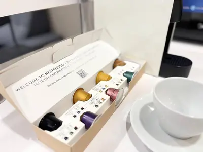 a box of different colored wine bottles next to a cup at Cempaka Apartment by Easy Nap in Kuala Lumpur