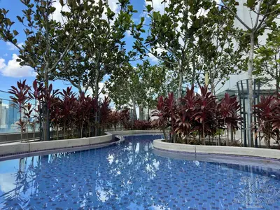 a large swimming pool with trees and a fence at Cozy Minimalist Condo In The Heart of Kuala Lumpur City 1BR in Kuala Lumpur
