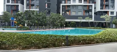 a swimming pool with lounge chairs in front of a building at KL Comfy Masterbedroom wt bathroom in Kuala Lumpur
