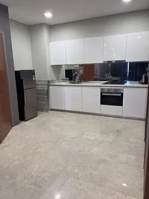 a kitchen with white cabinets and a black refrigerator at Sky Suite KLCC By near klcc in Kuala Lumpur