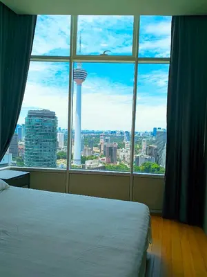a bedroom with a view of the space needle from a window at Sky Suite KLCC By near klcc in Kuala Lumpur