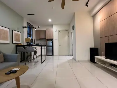 a living room and kitchen with a couch and a table at Regalia Residences and suits By Comfortcorner in Kuala Lumpur