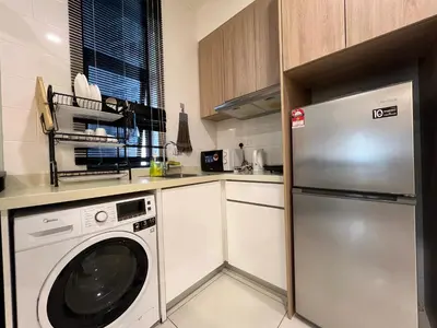 a kitchen with a refrigerator and a washing machine at Regalia Residences and suits By Comfortcorner in Kuala Lumpur