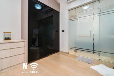 a large glass shower in a room with a wooden floor at 1BR| Rooftop Twin Towers View l Near LRT in Kuala Lumpur