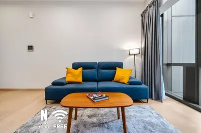 a blue couch with yellow pillows in a living room at 1BR| Rooftop Twin Towers View l Near LRT in Kuala Lumpur