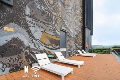 a wall with chairs and a mural on a building at 1BR| Rooftop Twin Towers View l Near LRT in Kuala Lumpur