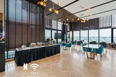 a dining room with tables and chairs and windows at 1BR| Rooftop Twin Towers View l Near LRT in Kuala Lumpur