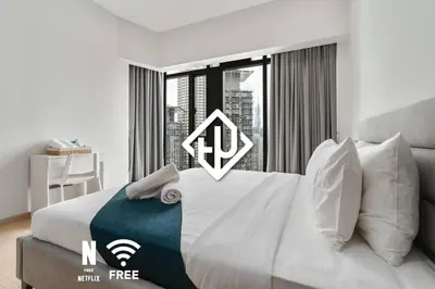 a bedroom with a large bed with a large window at Comfy 1BR with Twin Towers View in Kuala Lumpur