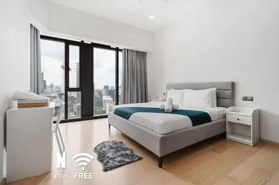 a bedroom with a bed and a large window at Comfy 1BR with Twin Towers View in Kuala Lumpur