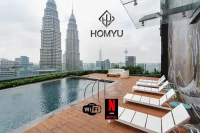 a swimming pool on the roof of a building with tall buildings at Comfy 1BR with Twin Towers View in Kuala Lumpur