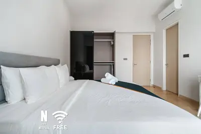a large white bed with a stuffed animal on top of it at Comfy 1BR with Twin Towers View in Kuala Lumpur