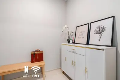 a white cabinet with two pictures on top of it at Comfy 1BR with Twin Towers View in Kuala Lumpur