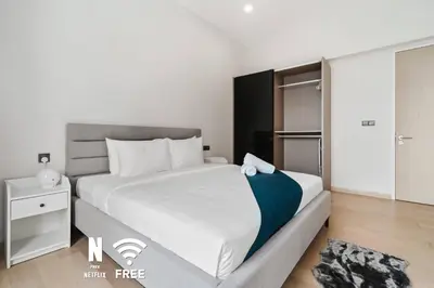 a bedroom with a large white bed and a closet at Comfy 1BR with Twin Towers View in Kuala Lumpur