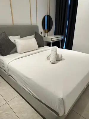 a large bed with white sheets and pillows at AXON RESiDENCE AT SERViCE APARTMENT in Kuala Lumpur