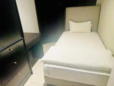a small bedroom with a white bed and a dresser at AXON RESiDENCE AT SERViCE APARTMENT in Kuala Lumpur