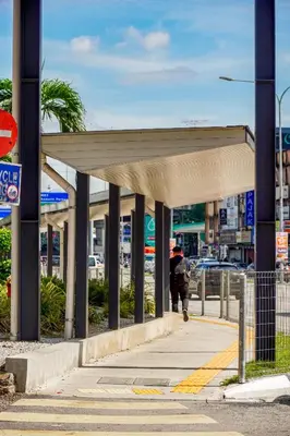 a person walking down a sidewalk under a canopy at Kuala Lumpur M Vertica Residence I Big Family Homestay \u5927\u5bb6\u5ead\u9002\u4f4f I Walking distance to MRT I \u9a6c\u4e2d\u82f1\u6587\u670d\u52a1 I Malay English Chinese in Kuala Lumpur