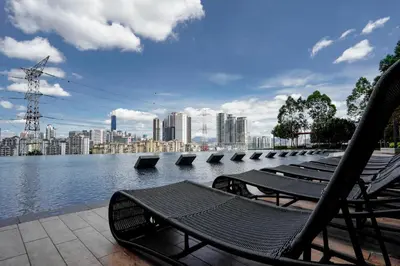 a row of benches sitting next to a body of water at Kuala Lumpur M Vertica Residence I Big Family Homestay \u5927\u5bb6\u5ead\u9002\u4f4f I Walking distance to MRT I \u9a6c\u4e2d\u82f1\u6587\u670d\u52a1 I Malay English Chinese in Kuala Lumpur