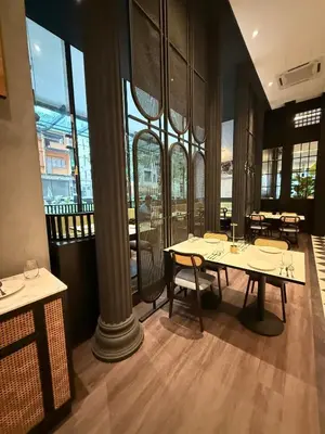 a dining room with tables and chairs and large windows at Exclusive Suites Bukit Bintang KL in Kuala Lumpur