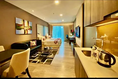 a hotel room with a bed and a living room at Exclusive Suites Bukit Bintang KL in Kuala Lumpur
