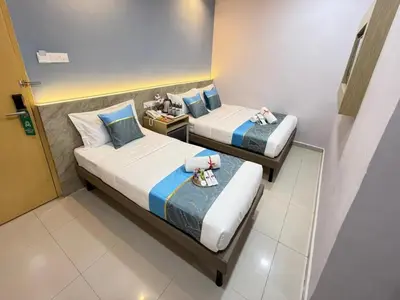 two beds in a hotel room with towels on them at AQ Hotel Bukit Bintang in Kuala Lumpur
