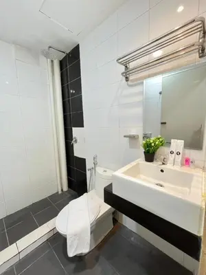 a white bathroom with a sink and a toilet at AQ Hotel Bukit Bintang in Kuala Lumpur