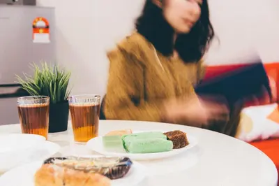 a table with a plate of food and two glasses of beer at KL Gateway Bangsar by Sleepy Bear in Kuala Lumpur