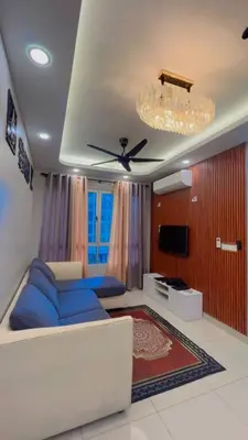 a living room with a blue couch and a ceiling fan at JMZ homestay in Kuala Lumpur
