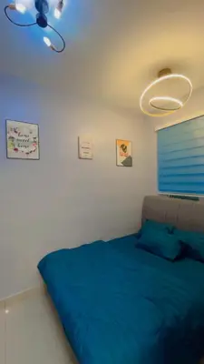 a bedroom with a blue bed and a ceiling fan at JMZ homestay in Kuala Lumpur