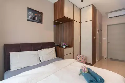 a bedroom with a white bed with a brown headboard at 3BR LSH33 KL Duke Highway Genting Free Parking in Kuala Lumpur
