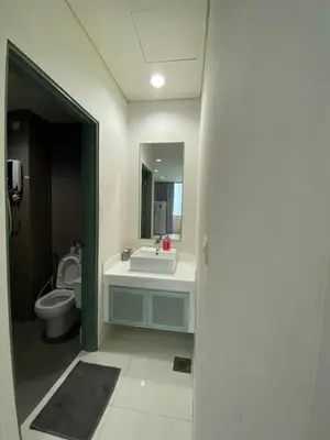 a bathroom with a sink and a toilet and a mirror at Summer Suites KLCC by Angel in Kuala Lumpur