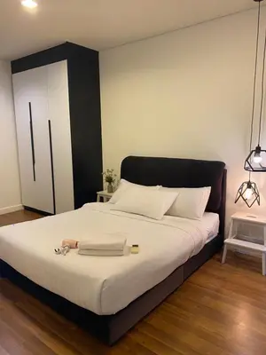 a bedroom with a large bed with a black headboard at Summer Suites KLCC by Angel in Kuala Lumpur