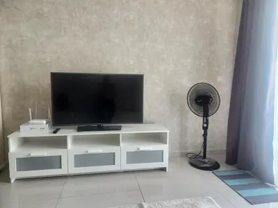 a white entertainment center with a television and a fan at 231tr facing golf view 3 rooms in Kuala Lumpur