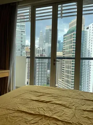 a bed in a bedroom with a view of a city at City centre, Bukit Bintang in Kuala Lumpur