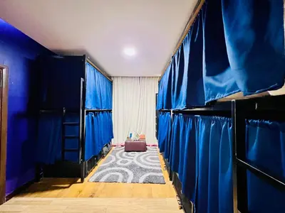 a room with blue walls and blue curtains at Regalia Space Hostel in Kuala Lumpur