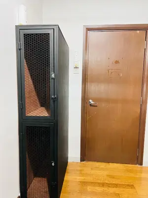 a black cabinet next to a wooden door at Regalia Space Hostel in Kuala Lumpur