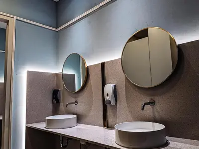 a bathroom with two sinks and two mirrors at Scarletz Suites KLCC by IH in Kuala Lumpur